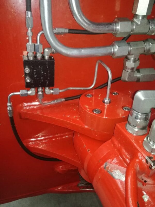 Hydraulic tube and divider block piping on a red machine