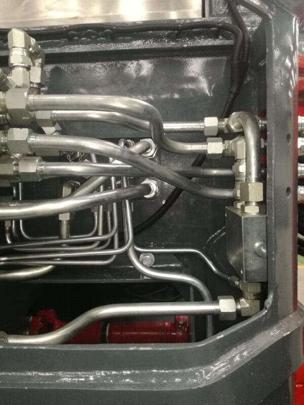 Hydraulic tube and fittings routed inside a machine frame