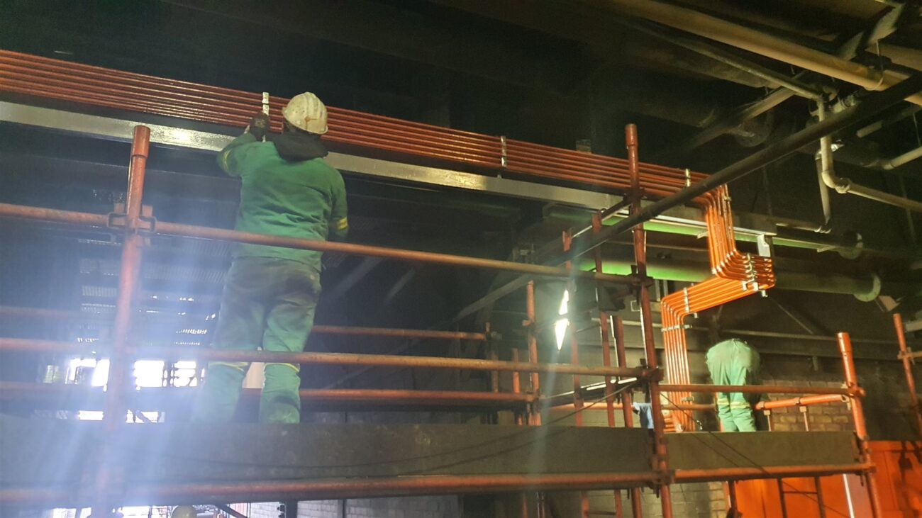 Hydraulic Squad team installing centralised lubrication lines on scaffolding at a plant