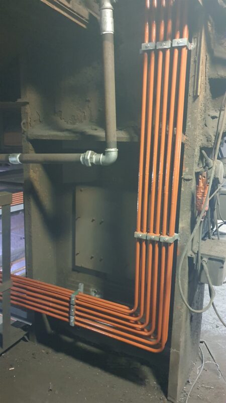 Newly installed lubrication lines with clamps on a vertical run
