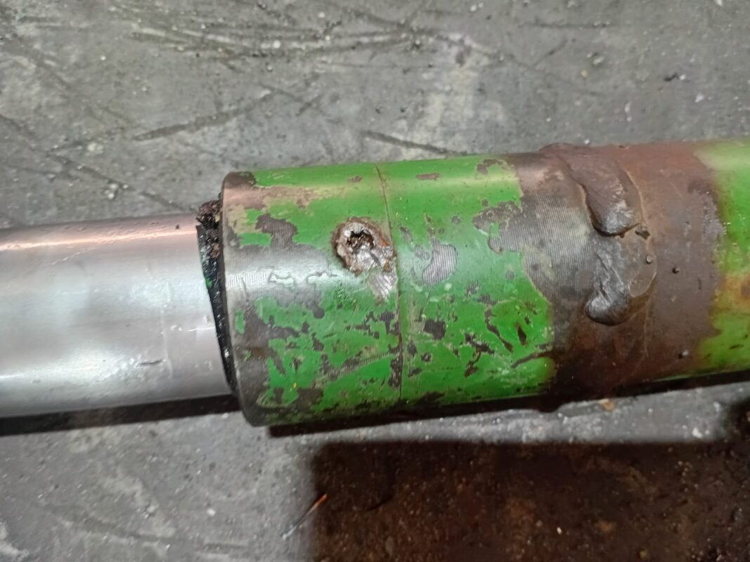 Damaged hydraulic cylinder port before repair