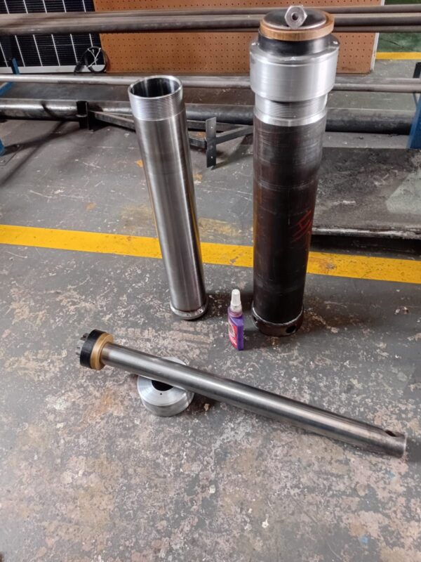 Hydraulic cylinder barrel, rod and gland laid out during a rebuild