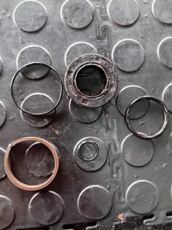 Worn hydraulic cylinder seals and wear rings removed during a cylinder reseal
