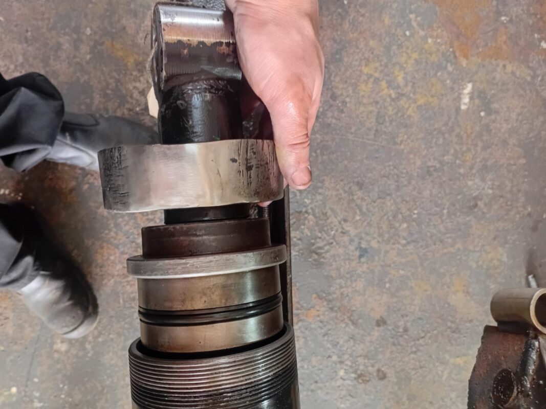 Piston and gland of a large hydraulic cylinder being rebuilt