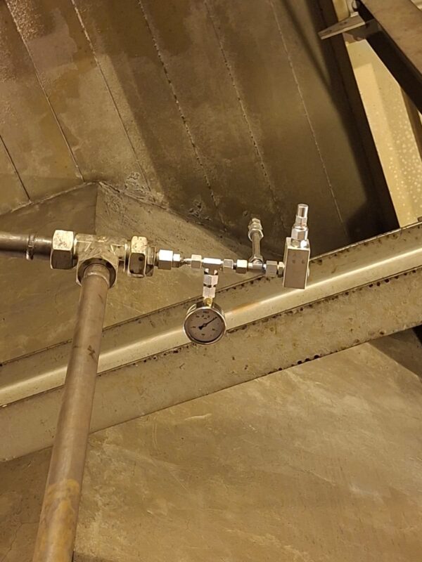 Pressure gauge and valve installed on accumulator pipework